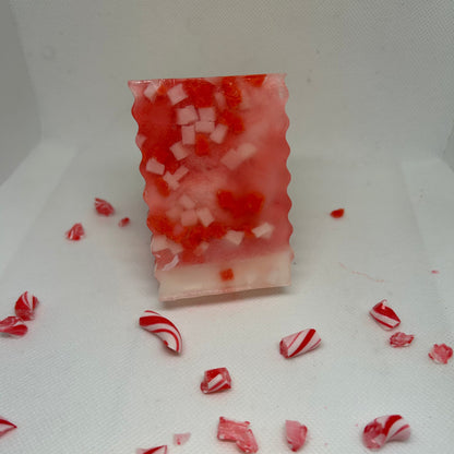 Handcrafted Frosted Cane soap with peppermint scent, surrounded by candy cane pieces, ideal for holiday gift sets and skincare.