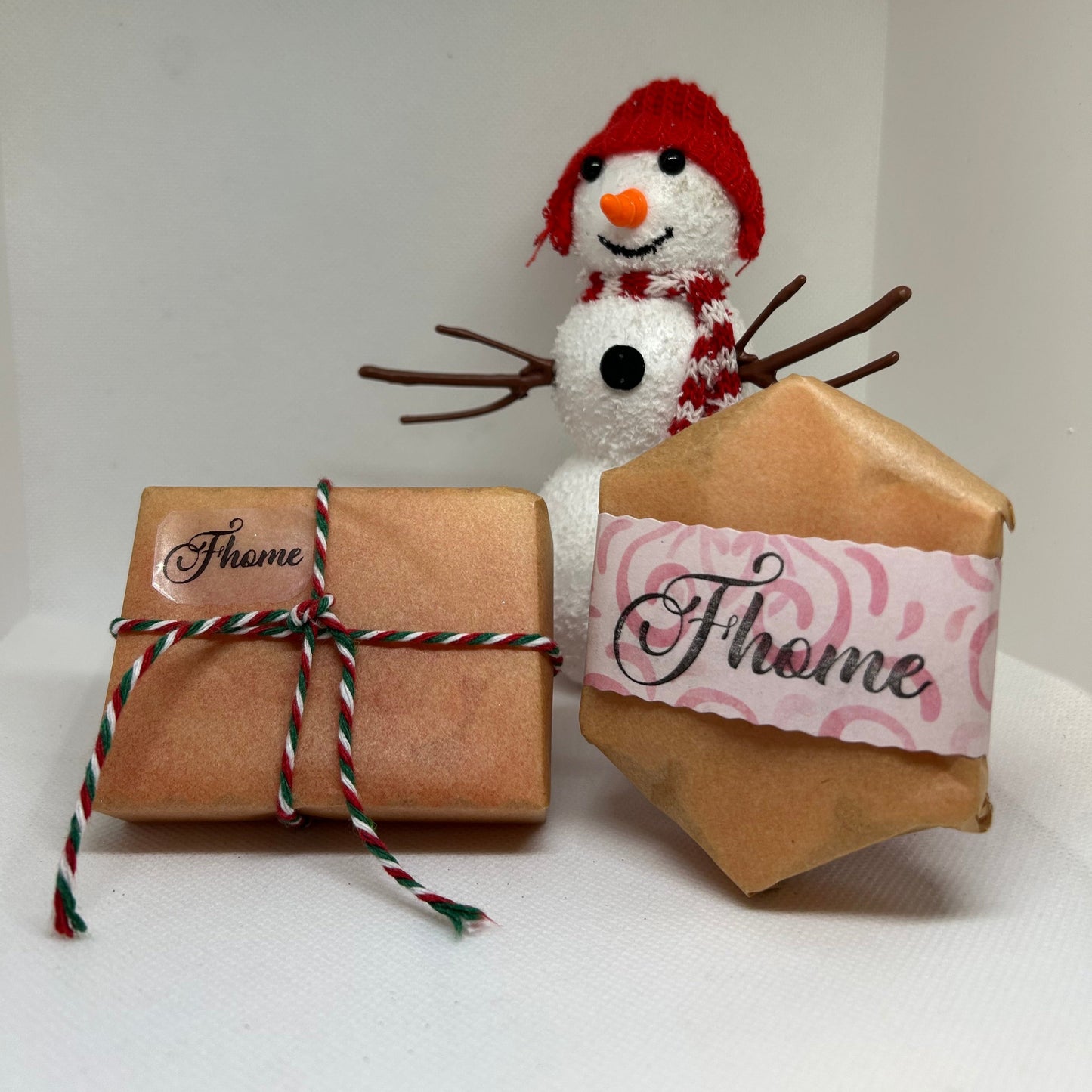 Soap gift set with festive packaging beside a cute snowman, perfect for holiday gifting and skincare.